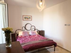 a bedroom with a bed with a vase on a table at Intera casa con due appartamenti indipendenti e vasca idromassaggio a Barbaresco, Langhe in Barbaresco