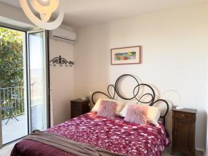 a bedroom with a bed with a purple comforter at Intera casa con due appartamenti indipendenti e vasca idromassaggio a Barbaresco, Langhe in Barbaresco