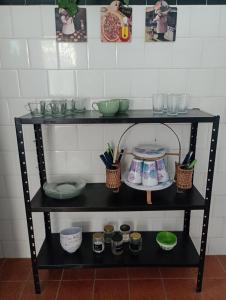 a black shelf with bowls and utensils on it at Refúgio da Aldeia - trabalho ou lazer! in São Pedro da Aldeia