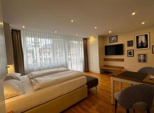 a bedroom with a bed and a desk and a television at Zum Franziskaner Dependance in Füssen