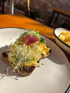 a sandwich on a white plate on a table at Mirador Johya Hotel in Bernal +29 photos