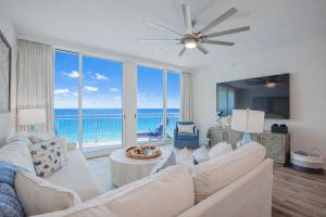 a living room with a white couch and a view of the ocean at Ocean Blue at 1805 Aqua in Panama City Beach