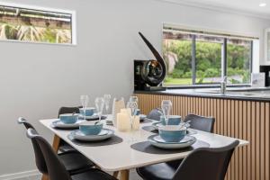 a dining room table with chairs and a kitchen at Clay Cottage in Waimauku +6 photos
