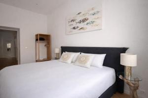 a bedroom with a large white bed with white pillows at Boutique Apartment Trieste in Trieste
