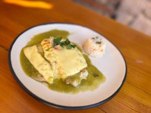a white plate with food on a wooden table at Mirador Johya Hotel in Bernal