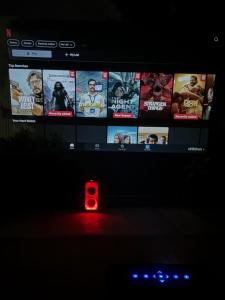 a television screen with a red light in the dark at Hampi Banana Farm House in Hospet