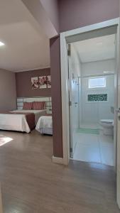 a room with a bedroom with a bed and a bathroom at Hospedagem Jardins de Gramado in Gramado +172 photos