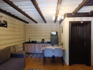 a living room with a table and chairs and a couch at Шепіт Карпат 2 in Synevyrsʼka Polyana