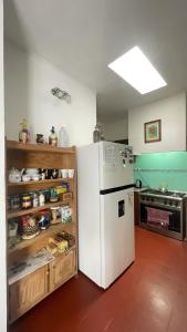 a kitchen with a white refrigerator in a room at Casa Mboyeré in Concepción del Uruguay