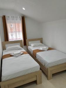two twin beds in a room with a window at Bulatović in Ðuranovići