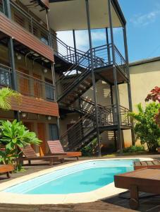 a building with a swimming pool and a staircase at Iguazú Urban Hotel Express in Puerto Iguazú
