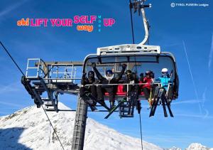 a group of people riding on a ski lift at TYROL PURElife Lodges in Sankt Jakob in Defereggen