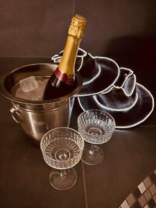 a bottle of champagne in a bucket with wine glasses at Romantic Room Šiauliai in Šiauliai