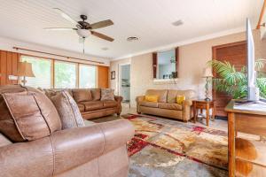 ein Wohnzimmer mit Sofas und einem Deckenventilator in der Unterkunft Ida's Oasis in Pine Bluff