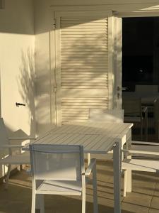 a table and chairs on a patio with a table and a chair at Casa Mare Sabaudia in Sabaudia