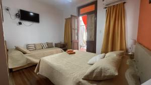 a bedroom with two beds and a television on the wall at Casa Mboyeré in Concepción del Uruguay