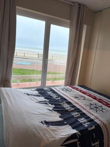a bedroom with a bed with a view of the beach at Châteaux de Sable Hardelot in Neufchâtel-Hardelot