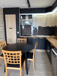 a kitchen with a black table and chairs at Châteaux de Sable Hardelot in Neufchâtel-Hardelot