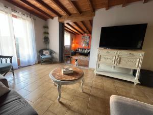 a living room with a large flat screen tv at Gîte LES GOUTTES 2 chambres 2 SDB in Courzieu