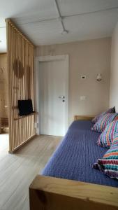 a bedroom with a bed with pillows and a television at La Libellula Rossa in Puos dʼAlpago