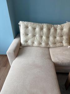a couch in a room with a blue wall at Апартамент център Поли in Sandanski