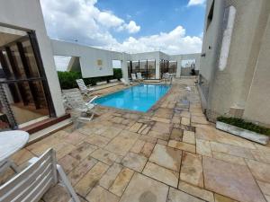 a swimming pool with chairs on a patio at Flat Próx. Campo de Marte, Anhembi e Espaço Unimed in São Paulo