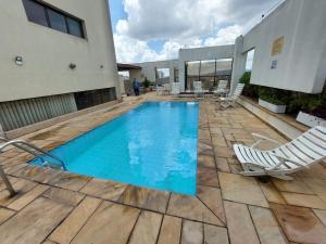 a swimming pool on a patio with chairs and a building at Flat Próx. Campo de Marte, Anhembi e Espaço Unimed in São Paulo +52 photos