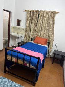 a bedroom with a bed and a window with a sink at Tourist Rendez Vous Hotel in Plaine Magnien