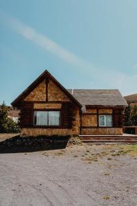 a log cabin house on a dirt road at Cabañas Aike in Caviahue