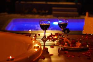 two glasses of wine on a table near a pool at ON2 Bungalov Villas in Dosemealti +11 photos