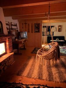 a living room with a basket hanging from the ceiling at La Patru Daci in Ocna Şugatag