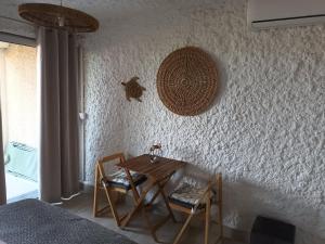 a table and chairs in a room with a wall at Beautiful sea view studio in Lumio +15 photos