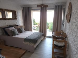 a bedroom with a bed and a table and windows at Beautiful sea view studio in Lumio