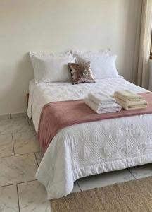 a bedroom with a bed with towels on it at Pousada Tia Moni in Blumenau