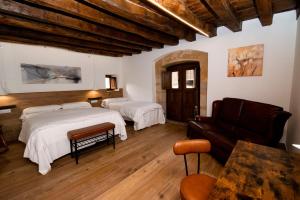 a bedroom with two beds and a couch in it at Palacio Soran in Leintz-Gatzaga