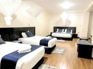 a hotel room with two beds and two tables at Delano Hotel in Bahir Dar
