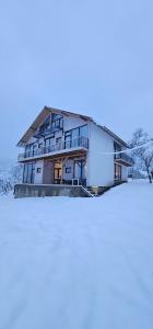 a house with snow on the ground at Zen Resort and Winery in Slănic