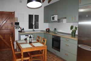 a kitchen with a table and chairs and a refrigerator at Casa Calera in Nerja