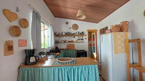 a kitchen with a table and a refrigerator in a room at Casa de Mar - Praia do Sagi in Baía Formosa