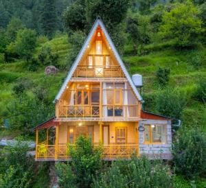 a large wooden house with a pitched roof at The nature view A shaped tree cottage in Banjār