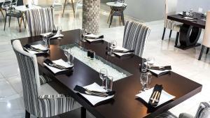a dining room with a table and chairs with wine glasses at Blueroof BYO in Bulawayo +10 photos
