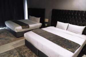 a hotel room with two beds and a bedskirts at Blueroof BYO in Bulawayo