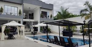 a hotel with a swimming pool and chairs and umbrellas at Villa Luna Hotel-Eventos in Carmen de Apicalá +17 photos