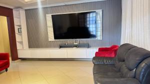 a living room with a couch and a flat screen tv at Mercy Guesthouse in Thohoyandou