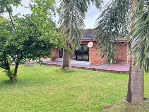 a brick house with two palm trees in a yard at Mercy Guesthouse in Thohoyandou +21 photos