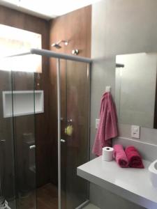a bathroom with a glass shower and a sink at Casa Compartilhada na CBF, granja comary in Teresópolis