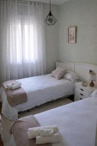 a bedroom with two beds and a window at A Casa Do Viso Do Chirin in Ponteareas