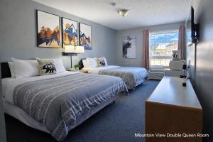 a hotel room with two beds and a window at Mountain View Inn in Canmore