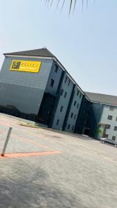 a building with a yellow sign on the side of it at Feliza Hotel and Suites in Abeokuta