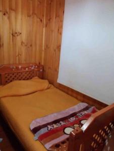 a bedroom with a bed with a blanket on it at Cabaña a pasos del mar in El Cerrillo